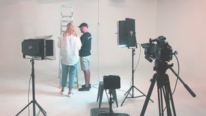 two people with back to camera in a white studio